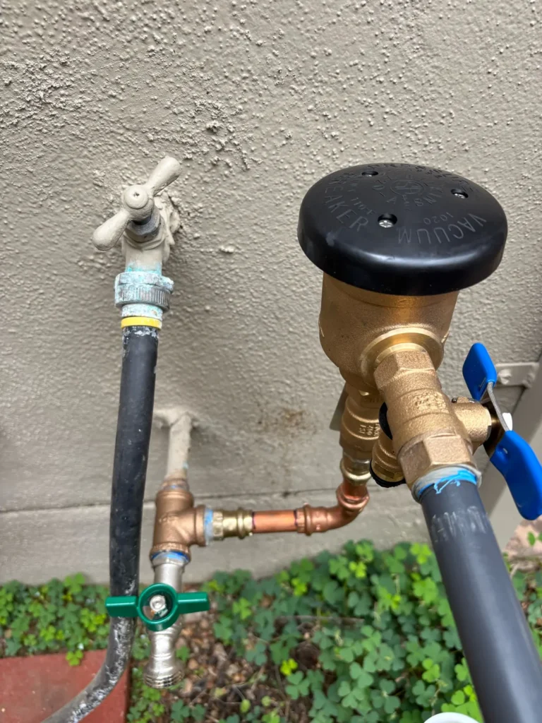 Close-up of a newly installed brass vacuum breaker and copper connections