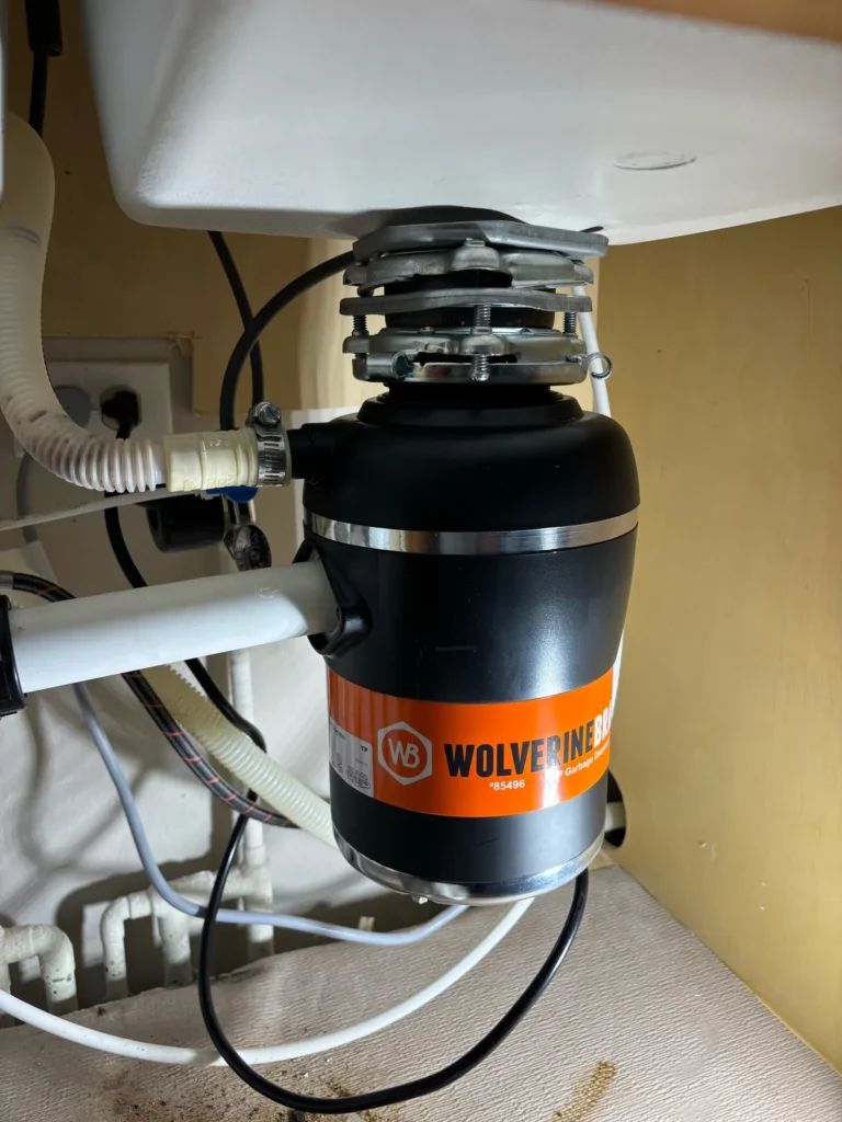 New garbage disposal installed and connected under the kitchen sink