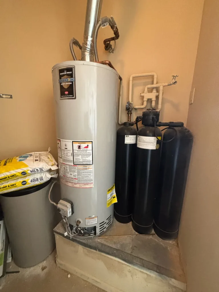 Gas water heater beside an aging multi-tank water treatment system